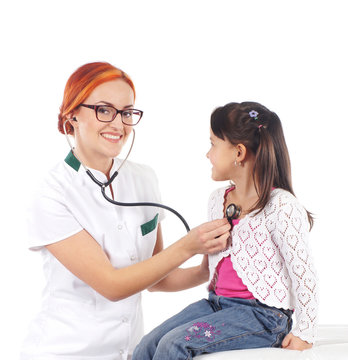Attractive young female doctor examining a little girl