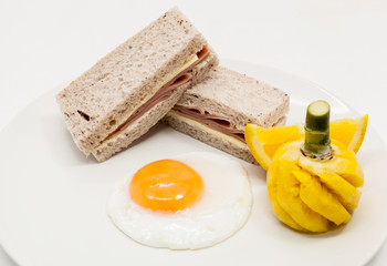 Breakfast with fried eggs, Sandwich, Orange and pineapple.