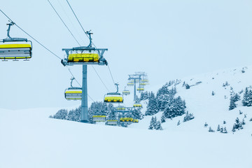 Fototapeta na wymiar Ski lift with chairs. Lift to the top of the mountain at ski re