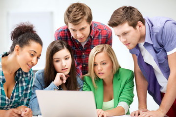 international students looking at laptop at school