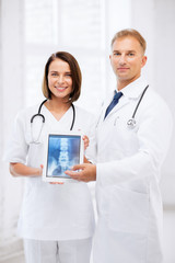 two doctors showing x-ray on tablet pc
