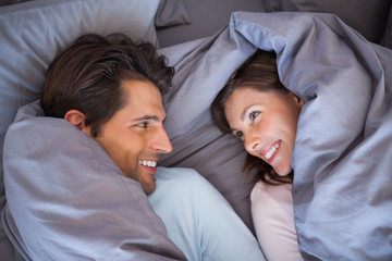 Couple having fun wrapped in their blanket