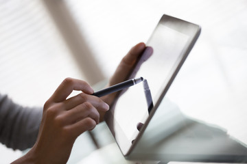 Close-up of woman working with stylus and digital tablet pc
