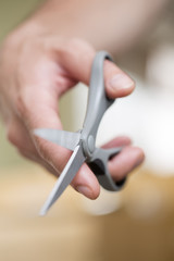Man's hand with scissors on a background.