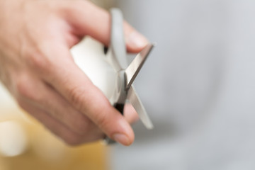 Man's hand with scissors on a background.