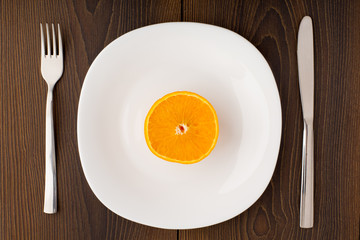 Half of orange on a white plate