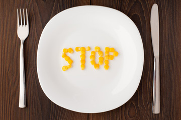 Word stop made of corn seeds on a plate