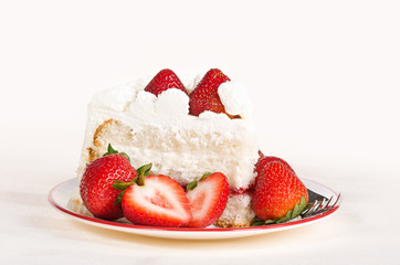 Slice of homemade strawberry whipped cream cake
