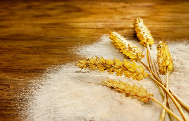 Wheat bunch and flour on vintage wood board © pinkyone