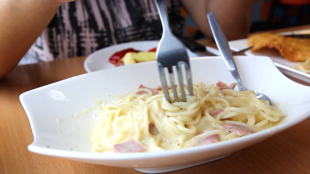 Closeup eating spaghetti carbonara on white plate