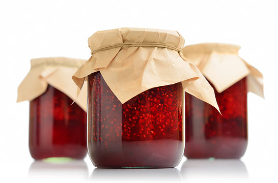 Three jars of raspberry jam on white background
