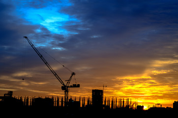 Industrial construction cranes and building silhouettes
