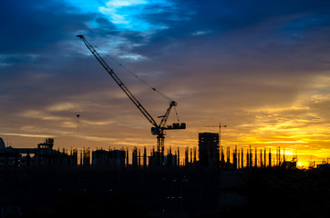 Industrial construction cranes and building silhouettes