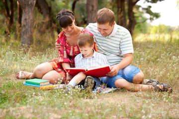 Naklejka na ściany i meble Happy family reading together.
