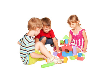 Three children playing and building together.