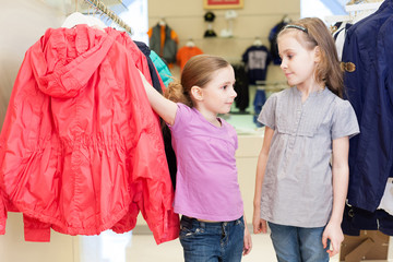 Two girls try on clothes in a modern store