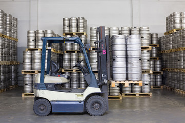 Forklift with beer kegs in stock brewery