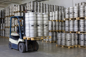 Forklift loading beer kegs in warehouse brewery