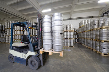 Forklift loading beer kegs in stock brewery
