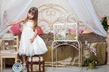 Photo sur Plexiglas Oiseaux en cages Petite fille dans la chambre tenant une cage avec un oiseau
