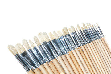 A set of brushes for painting in a row of artists. On a white ba