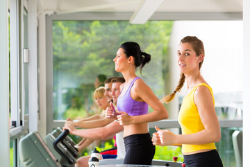 People in sport gym on treadmill running