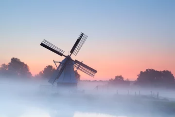 Garden poster Morning with fog charming Dutch windmill in morning fog