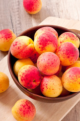 bowl of fresh apricots on wooden table