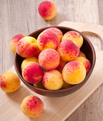 bowl of fresh apricots on wooden table
