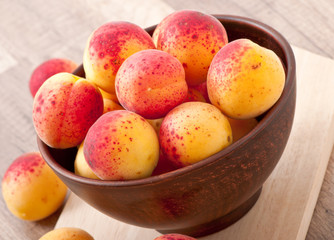 bowl of fresh apricots on wooden table