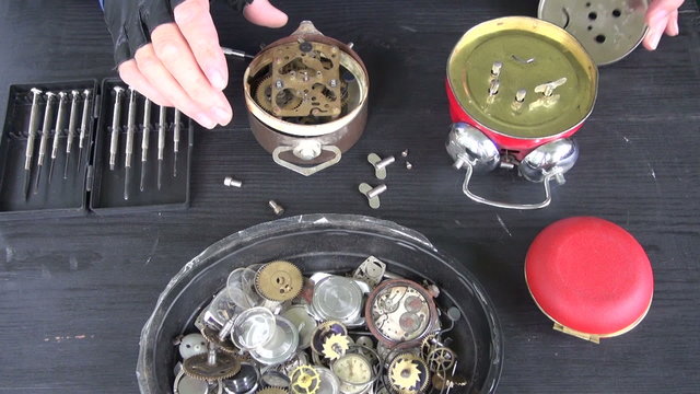 clockmaker hands repairing old alarm-clock. Clock repair