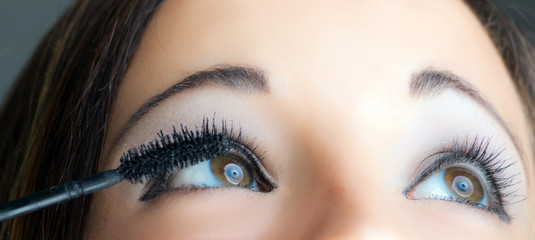 Obraz premium Portrait of a beautiful woman applying makeup