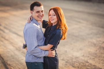 couple embracing standing on the road in the dust