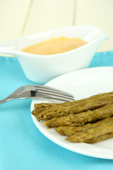Asparagus on plate, on wooden background