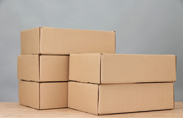 Parcels boxes on wooden table, on grey background