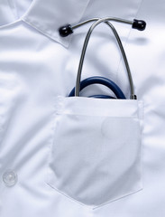 A medical stethoscope in the pocket of an overall, closeup