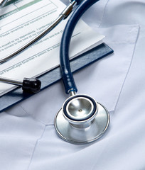 A stethoscope  and a clipboard on a medical uniform, closeup
