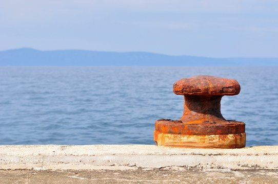 Old, rusty mooring bollard on port of Podgora, Croatia