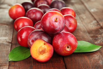 Ripe plums on wooden table close-up