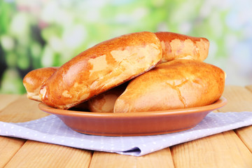 Fresh baked pasties, on wooden table, on bright background