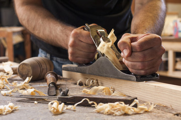 carpenter working  with  plane  on wooden background - Powered by Adobe