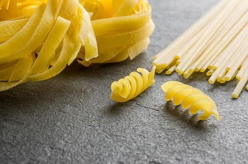 Verschiede Pastasorten auf einem Schieferhintergrund