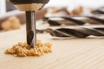 drilled hole with saw dust on wood table