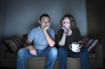 couple watching television bored - Powered by Adobe