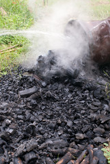 Fototapeta na wymiar Dousing charcoal to reduce temperature before packing