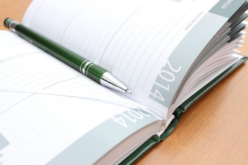 Closeup of green pen on calendar