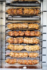 roasting chickens on a vertical grill
