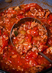 Spaghetti bolognese sauce being fried on a pan, with onions, mea