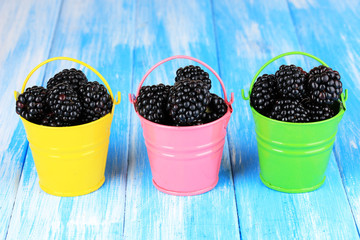 Fototapeta na wymiar Sweet blackberries in buckets on table close-up