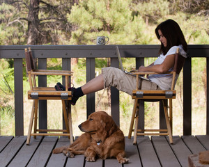 Woman relaxing with laptop computer and dog